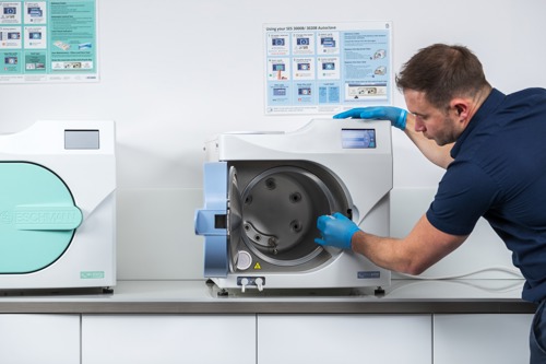 Man in a navy blue shirt servicing an autoclave